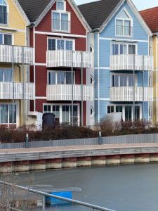a row of houses next to a body of water at Design Appartment Picasso am Yachthafen Greifswald in Greifswald