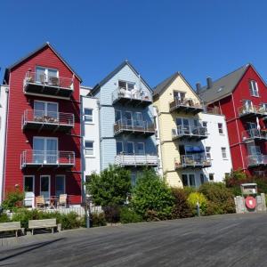a row of colorful houses with a bench in front of them at Design Appartment Picasso am Yachthafen Greifswald in Greifswald