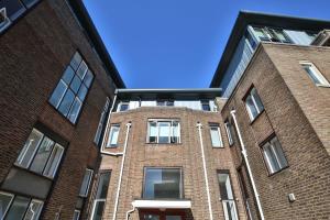 a brick building with a blue sky in the background at For Students Only - Library Lofts in Exeter in Exeter