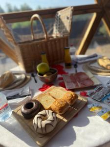 a table with bread and donuts and a basket at El Molí Glamping Escapada Romántica in Adzaneta +81 photos