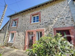 a stone house with red windows and a brick building at Chez Marguerite et Lucienne in Bussière-Dunoise
