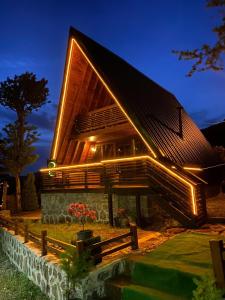 een houten huis met 's nachts verlichting bij Ilıca Bungalov in Ardeşen
