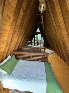 een slaapkamer met een bed in een houten hut bij Ilıca Bungalov in Ardeşen