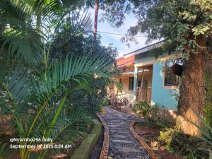 a stone path in front of a house with palm trees at Hakuna matata in Gulu