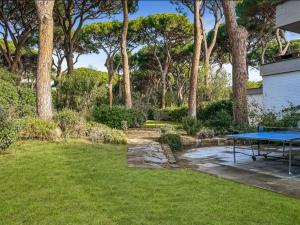 a picnic table in a yard with trees at Villa Nannia Beautiful Roccamare Private Beach in Castiglione della Pescaia