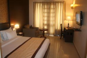 Un dormitorio con una cama y una sala de estar. en The Royal Retreat, en Ranchi