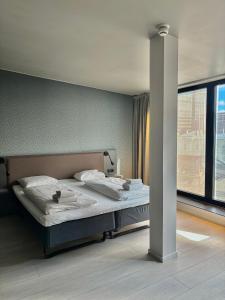 a bed in a room with a large window at Comfort Hotel Xpress Central Station in Oslo
