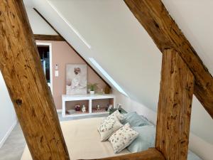 een kamer onder de trap met een bed en kussens bij Appart Saint Jo in Colmar