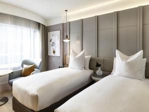 two beds in a hotel room at The Porter House Hotel Sydney - MGallery in Sydney