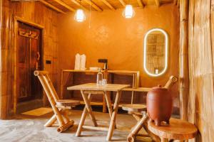a room with a table and chairs and a mirror at KaatiKaadu in Sakleshpur