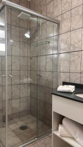 a shower with a glass door in a bathroom at Suítes Aqui é Seu Lugar Itaguá in Ubatuba +30 photos