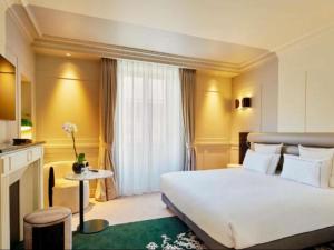A bed or beds in a room at La Licorne Hotel & Spa Troyes - MGallery Collection