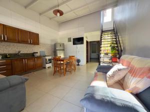 a large living room with a couch and a kitchen at Apartamento com 2 quartos, 2 banheiros e Garagem em sinop in Sinop