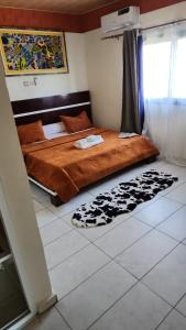 AssinieRésidence AL的卧室配有一张床,地板上铺有地毯