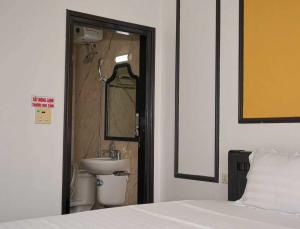 a bedroom with a bed and a sink and a mirror at Phố Xưa Central Hotel Hoa Lư - Ninh Bình in Ninh Binh