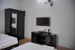 a room with a bed and a television on a wall at Phố Xưa Central Hotel Hoa Lư - Ninh Bình in Ninh Binh