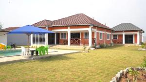 AssinieRésidence AL的一个带桌子和蓝伞的房子