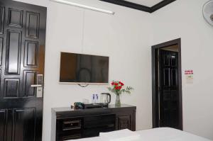a bedroom with a bed and a tv on the wall at Phố Xưa Central Hotel Hoa Lư - Ninh Bình in Ninh Binh +10 photos