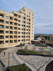 a large building with a playground in front of it at Sokolis Apartman in Kragujevac