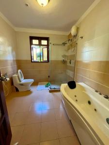 a bathroom with a tub and a toilet and a sink at Coastal bliss apartment in Mombasa +31 photos