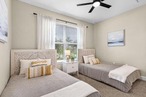 two beds in a bedroom with a ceiling fan at Charming, Comfort and Relaxation Await! - Casa Bella - Roelens in Matlacha