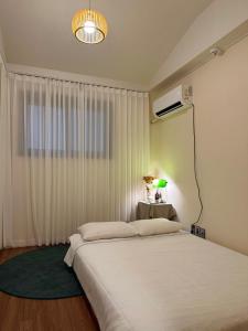 a bedroom with a large white bed and a window at Dal Dam, a pet-friendly accommodation in the west of Jeju, a private underground bunker event room for family groups in Ŭmbu-dong