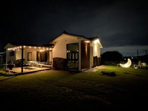 a house lit up at night with lights at Dal Dam, a pet-friendly accommodation in the west of Jeju, a private underground bunker event room for family groups in Ŭmbu-dong