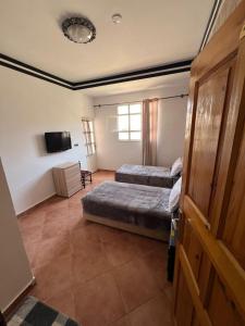 a bedroom with two beds and a flat screen tv at BananaHouse in Tamri