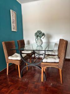 a glass table with two chairs and a vase on it at For4Apartment in Bicas +10 photos