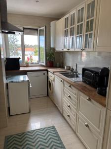 a kitchen with white cabinets and a sink and a microwave at For4Apartment in Bicas