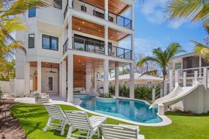 an exterior view of a house with a pool and a slide at Between the Waves - Siesta Key Luxury Home in Bailey Hall +69 photos