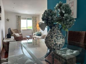 a vase filled with flowers on a glass table in a living room at For4Apartment in Bicas