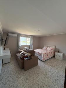 a bedroom with a bed and a couch and a bed at House in a great location in Petrolina