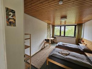 a bedroom with two beds and a wooden ceiling at Zimmer 2 in Gomadingen