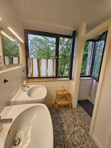 a bathroom with a sink and a tub and a window at Zimmer 2 in Gomadingen +1 photo