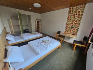 a room with two beds and a table and a chair at Zimmer 4 in Gomadingen