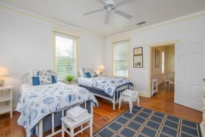 a bedroom with two beds and a table at Paradise Palms by Tybee Cottages in Tybee Island