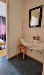 a bathroom with a sink and a mirror at Zimmer 8 in Gomadingen