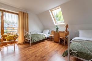 ザコパネにあるFamily Villa - Widok na Tatry - Jacuzzi i Grillのベッド2台と机と窓のある寝室