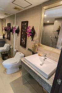 a bathroom with a sink and a toilet and a mirror at Tira Tiraa Condominium in Hua Hin