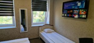 a bedroom with a bed and a tv on the wall at Pink House in Rīga