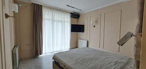 a bedroom with a bed and a large window at Mtrediani Wine Lodge in Kobuleti