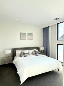 a bedroom with a large white bed with two pillows at Williamstown Village in Williamstown +17 photos