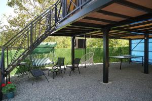 a patio with chairs and a table and a staircase at your dream cottage in Ts'ikhisdziri