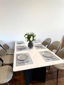 a white table with chairs and a vase of flowers at Williamstown Village in Williamstown