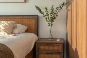 a vase of flowers on a table next to a bed at 3BR Sunset View Retreat Steps from the Beach by Cyprus Horizons in Oroklini +26 photos