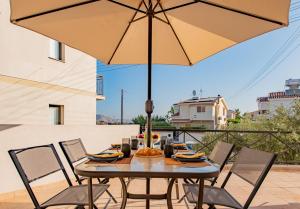 a table and chairs with an umbrella on a patio at 3BR Sunset View Retreat Steps from the Beach by Cyprus Horizons in Oroklini