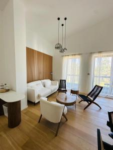 a living room with a white couch and chairs at White & Wood Suite C302, at Euphoria SPA Borovets in Borovets