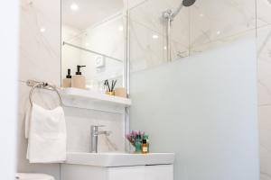 une salle de bain blanche avec un lavabo et un miroir dans l'établissement TelMar SeaView, à Oroklini 47 autres photos