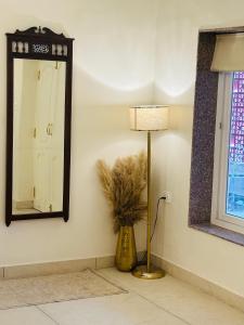 a room with a mirror and a lamp and a vase at Shekhawat Sadan in Jaipur